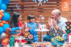 a man and two children sitting at a table with a cake in front of them