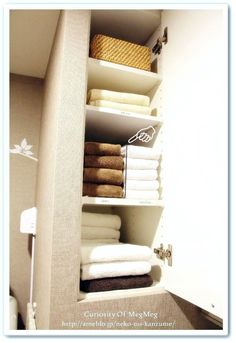 towels are stacked on shelves in the bathroom, and one is folded up to dry