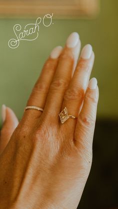 a woman's hand holding a diamond ring with the word start written on it