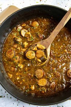 a skillet filled with food and a wooden spoon