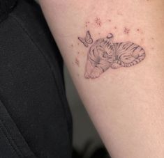 a small tiger tattoo on the arm with a butterfly around it's neck and head