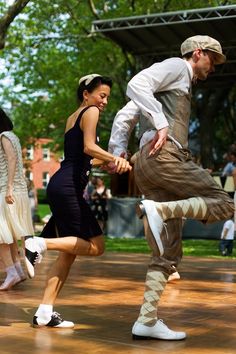 a man and woman are dancing in the park