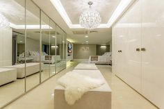 a large white room with mirrored walls and floor to ceiling closet doors, mirrors on the wall