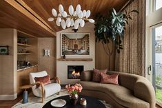 a living room filled with furniture and a fire place next to a large glass window