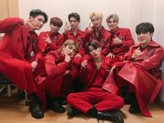 a group of young men in red suits posing for a photo with their hands on their hips