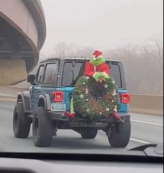 a truck driving down the road with a christmas tree on it's flatbed