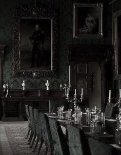 a long table with many chairs around it in a room that has paintings on the wall