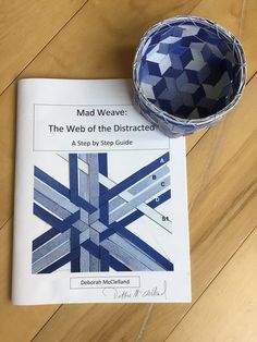 a book about the web of the distracted on a wooden floor with a blue bowl next to it