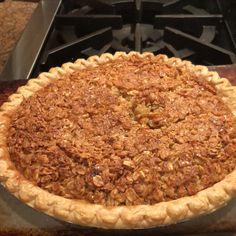 a pie sitting on top of a metal pan next to an open stove burner