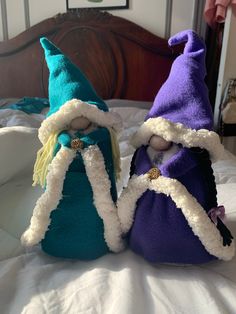 two stuffed gnomes sitting on top of a bed