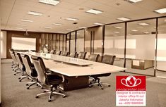 an empty conference room with chairs and a large table in the center, surrounded by glass partitions