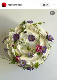 a white cake with purple and pink flowers on it