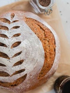 a loaf of bread sitting on top of a wooden cutting board next to some spices