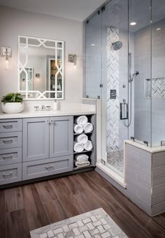 a bathroom with gray cabinets and white towels