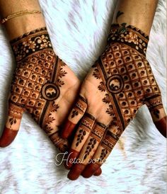 two hands with henna tattoos on them