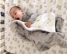 a baby is laying in a crib with a blanket