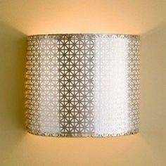 a wall light that is on the side of a wall next to a lamp shade