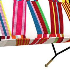 a multicolored striped bench sitting on top of a white floor