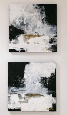 two black and white paintings hanging on the wall