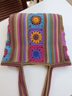 a multicolored crocheted bag sitting on top of a table