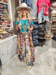 a woman wearing a hat and dress in a clothing store