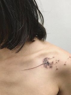 a woman's shoulder with a dandelion tattoo on her left side,