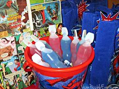 a red bucket filled with lots of bottles of toothpaste on top of a table