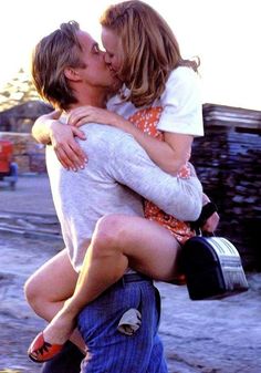 a man and woman kissing each other on the street