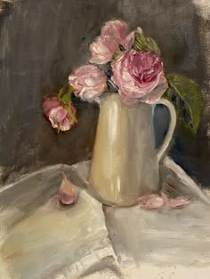 a painting of pink roses in a white pitcher on a table cloth with an open book