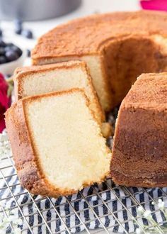 a bundt cake with one slice cut out on a cooling rack next to blueberries