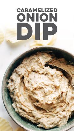 a bowl filled with dip next to chips on top of a white tablecloth and text that reads caramelized onion dip