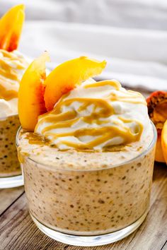 two desserts with peaches and whipped cream are on a wooden table next to sliced oranges