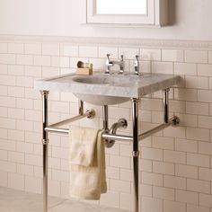 a bathroom sink sitting under a mirror next to a white tiled wall in a room