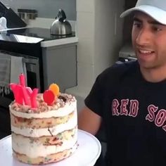 a man holding a cake with candles on it