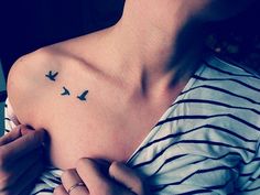 a woman's chest with two birds on the left side of her body and one is