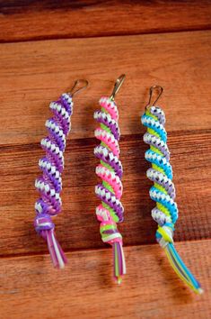 three different colored bracelets sitting on top of a wooden table