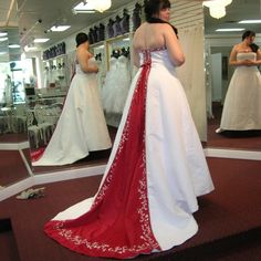 a woman in a red and white dress looking at herself in the mirror with her reflection