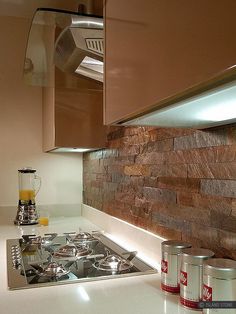 a stove top oven sitting inside of a kitchen next to two cans of orange juice