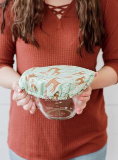 a woman holding a cake in her hands with the frosting on it's top