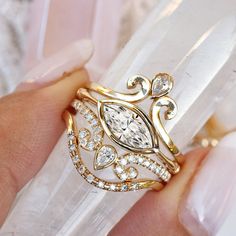 a close up of a person's hand holding a ring with diamonds on it