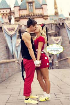 a man and woman kissing in front of a castle