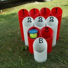 a bunch of red and white cups sitting on top of a green grass covered field