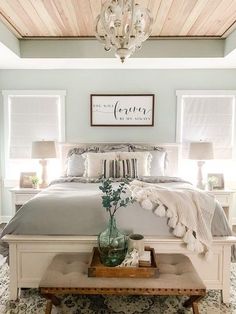 a bedroom with a bed, nightstands and a chandelier above the bed