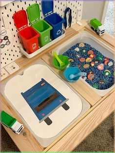 a table that has some toys on it and in the middle of it is a blue machine