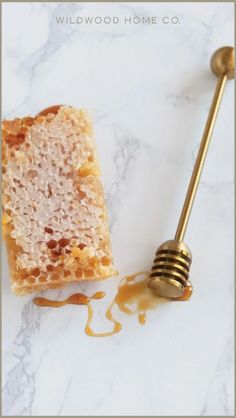 a piece of cake with honey drizzled on it next to a spoon