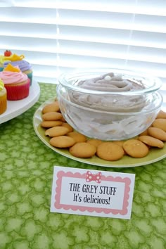 a table topped with cupcakes and cakes next to a sign