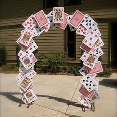 an arch made out of playing cards in front of a house