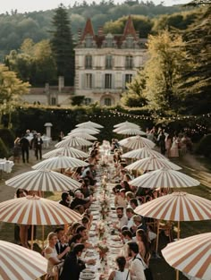 a group of people sitting at tables under umbrellas