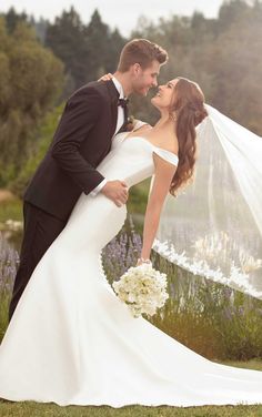 a bride and groom pose for a wedding photo in front of lavenders at sunset