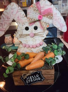 a wooden box filled with carrots sitting on top of a counter next to a sign